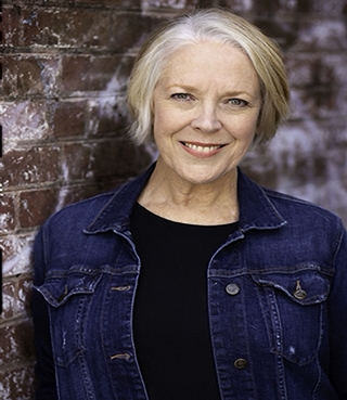 A headshot of Wendy Welch wearing a black shirt and a jean jacket.