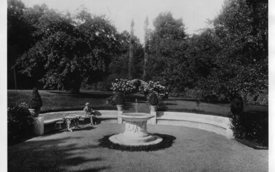 Black and white photo of Daniel Chester French reading at a fountain
