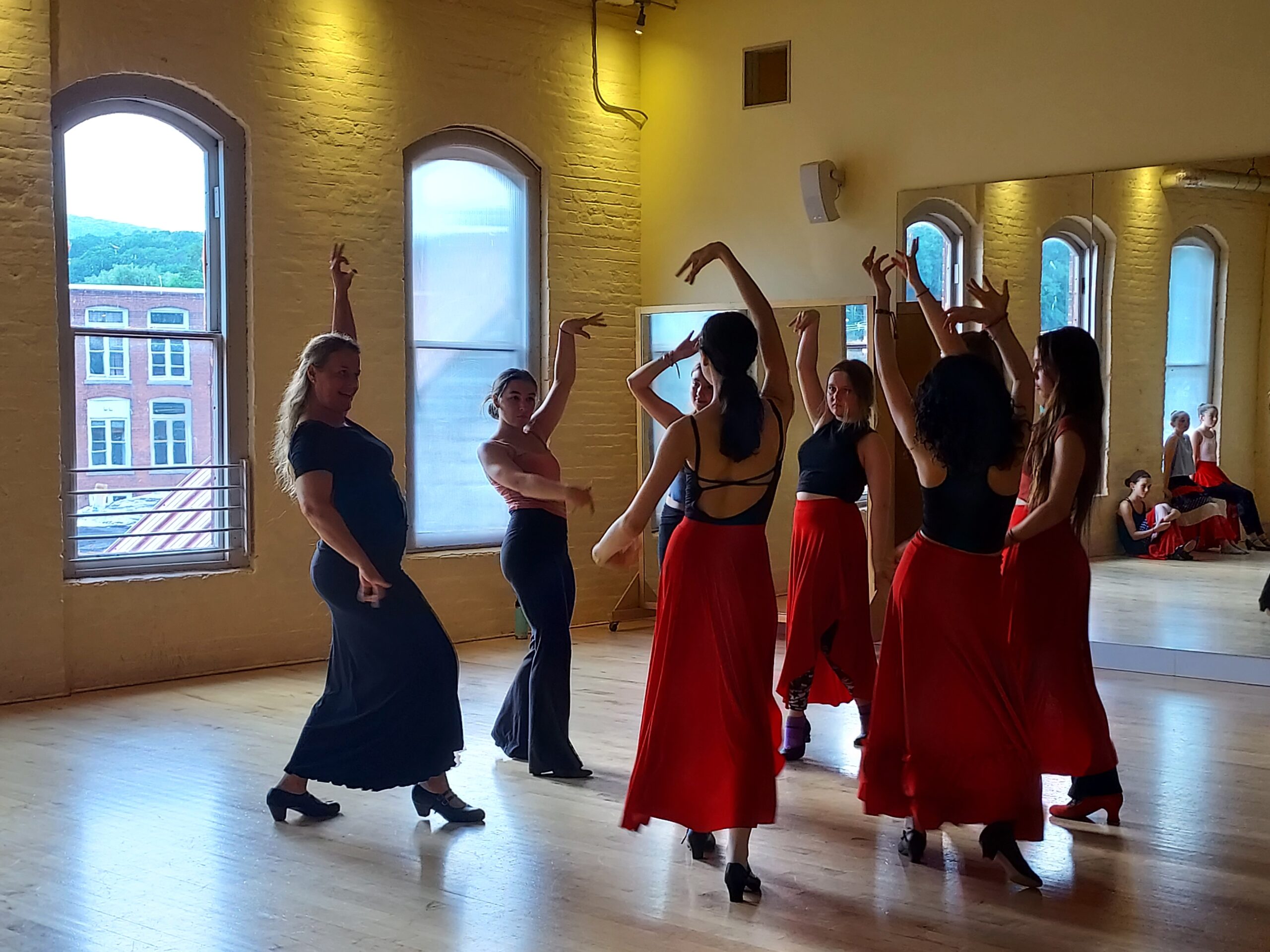 A group pf dancers doing flamenco in a dance studio